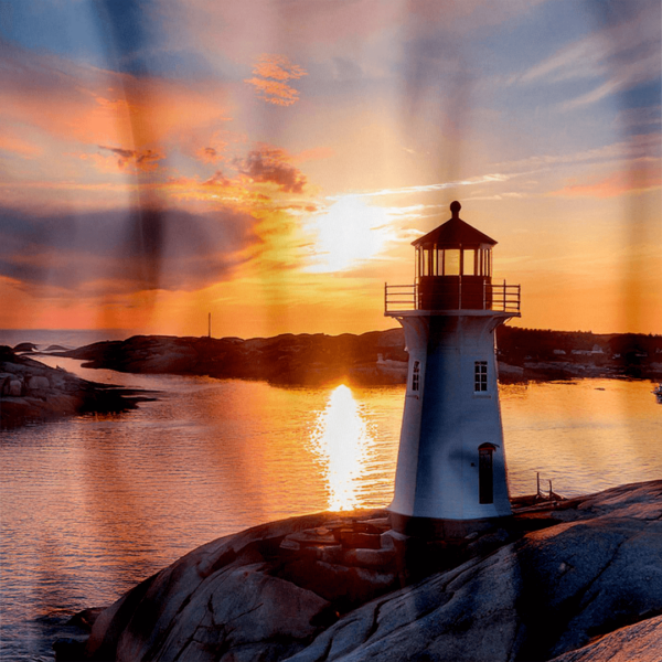 **Alt Text:** Close-up of a shower curtain featuring Peggy’s Cove Lighthouse during a dramatic sunset. The lighthouse, perched on smooth granite rocks, is silhouetted against a vibrant sky filled with rich oranges, pinks, and purples. The golden sun reflects off the calm ocean water, creating a striking path of light leading toward the horizon. The overall atmosphere is warm, peaceful, and captivating.