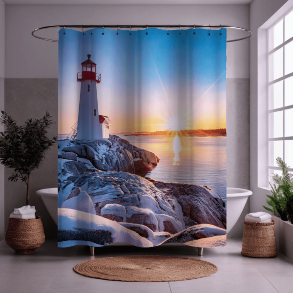 **Alt Text:** Shower curtain design featuring a winter sunrise scene at Peggy’s Cove Lighthouse. The lighthouse stands tall with a red top and white base on rugged, snow-covered granite rocks. The early morning sun rises over the calm water, casting a warm golden light across the scene and creating a gentle reflection on the ocean’s surface. The sky transitions from deep blue to soft pastels, creating a peaceful coastal atmosphere.